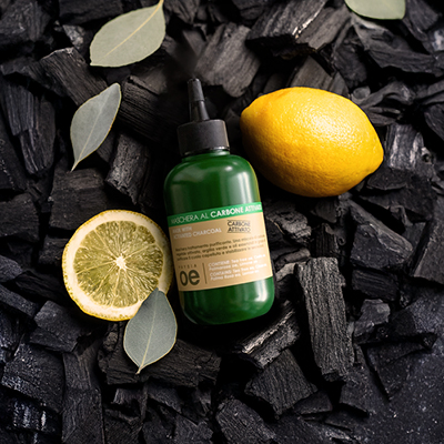 immagine del prodotto della maschera al carbone ambientata su sfondo nero con carbone e limoni 